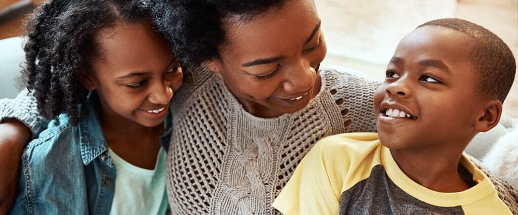 Shot a mother and her children sitting on the sofa together indoors
