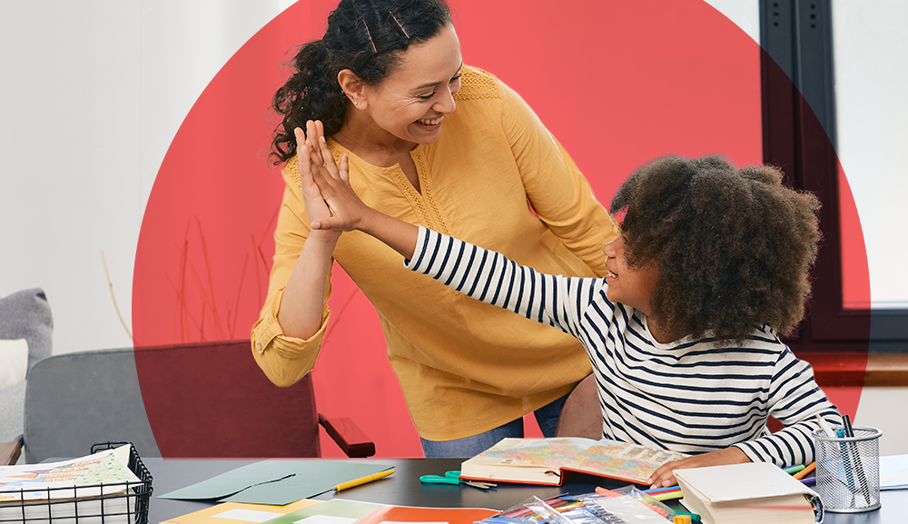 Student enthusiastically high-fiving a behavior technician during a positive reinforcement moment in therapy